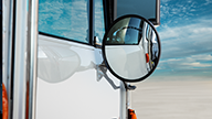 Peterbilt Model 520 Vocational White Truck on Convex Mirror Closeup on Dry Mud Flats Background - Thumbnail